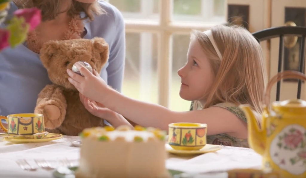Girl giving tea to stuffed bear
