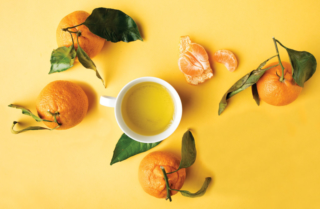 cup of tea surrounded by oranges and peels