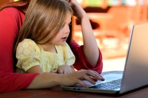 Child at laptop with parent