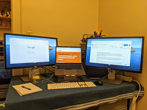 a laptop and two computer monitors on a desk