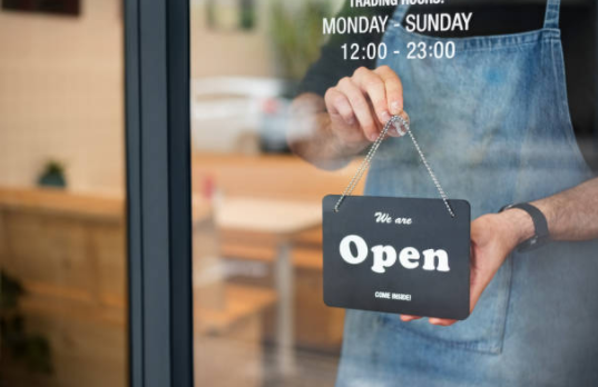 a person holding an open sign